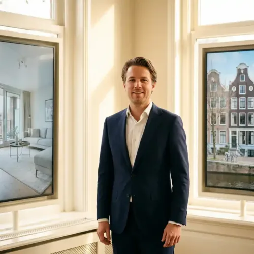 Professionele makelaar in marineblauw pak tussen moderne appartement- en klassieke grachtenpand displays in kantoor