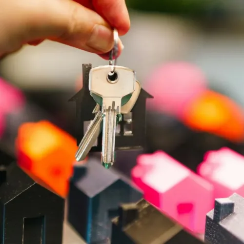 Persoon met een huissleutel in de handen bij de overdracht van een woning.