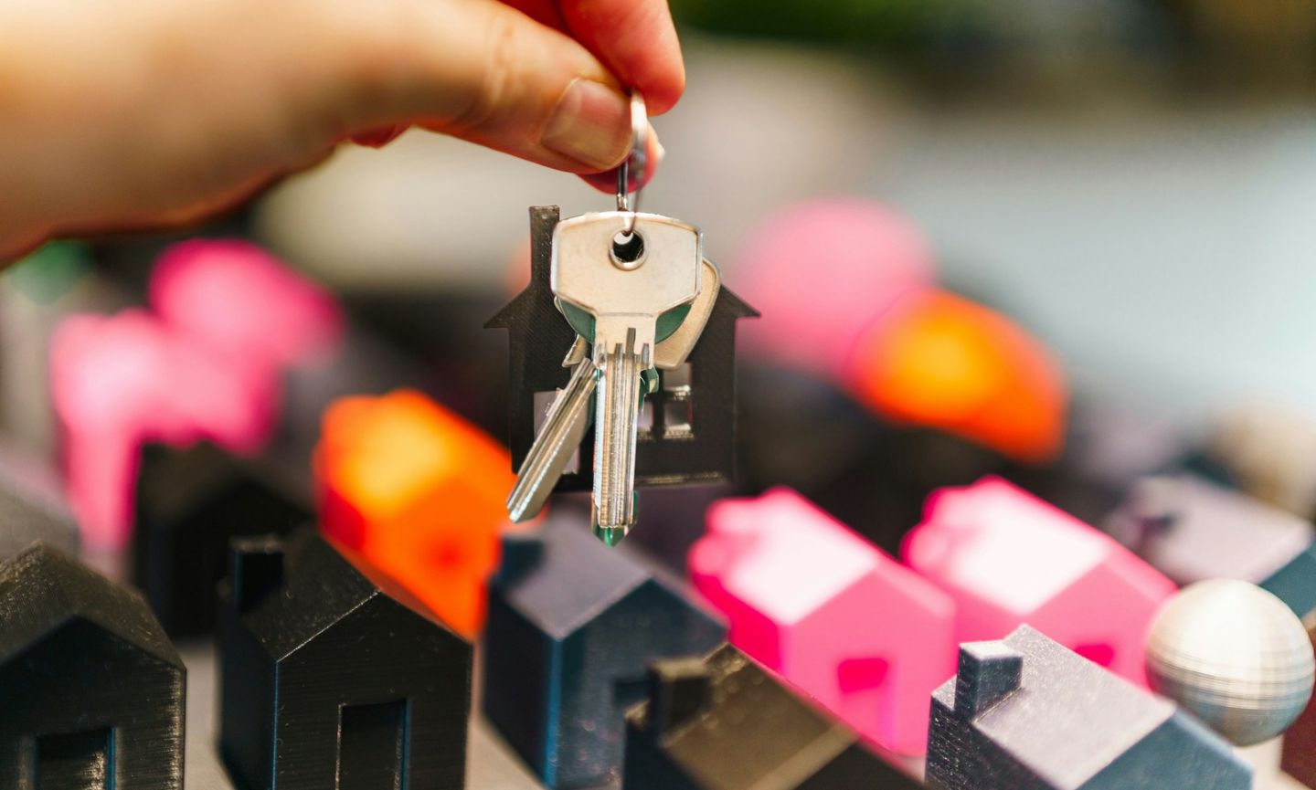 Persoon met een huissleutel in de handen bij de overdracht van een woning.